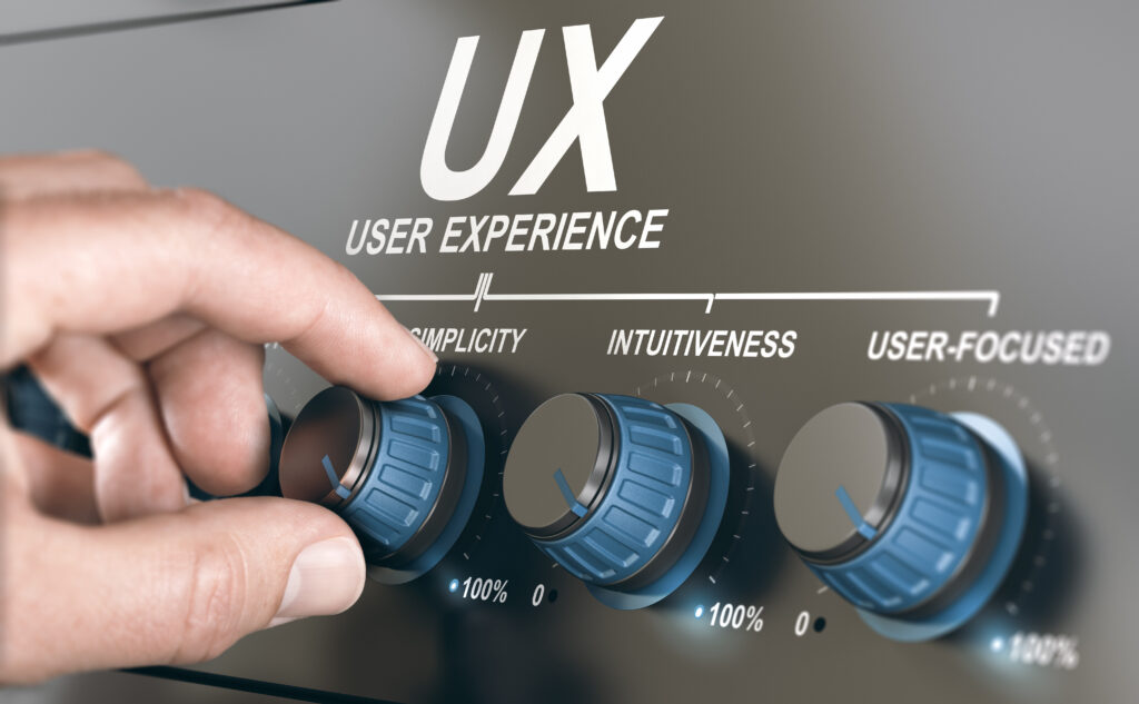 Nahaufnahme einer Hand, die einen von drei blauen Knöpfen auf einem metallischen Bedienfeld mit der Aufschrift „UX User Experience“ einstellt. Die Knöpfe mit den Aufschriften „Einfachheit“, „Intuitiv“ und „Benutzerfokussiert“ symbolisieren die Kernaspekte des UX-fokussierten Designs zur Verbesserung der allgemeinen Benutzererfahrung.
